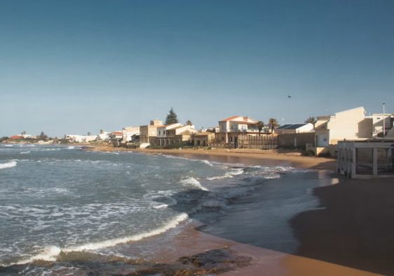 Beautiful coastal view of a sandy beach in Sicily, Italy under a clear blue sky.