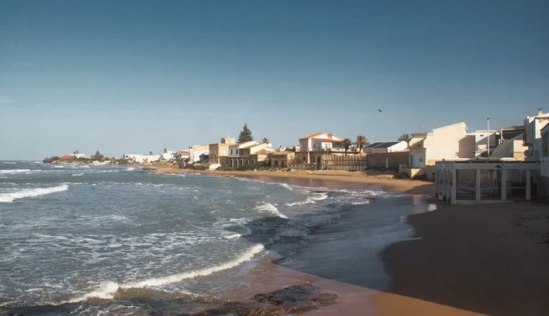 Beautiful coastal view of a sandy beach in Sicily, Italy under a clear blue sky.