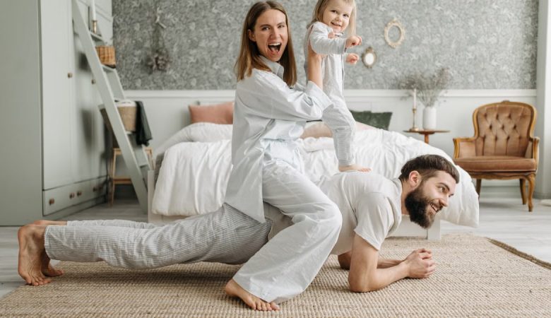 A cheerful family enjoys bonding and playing together on a cozy morning in a stylish bedroom.